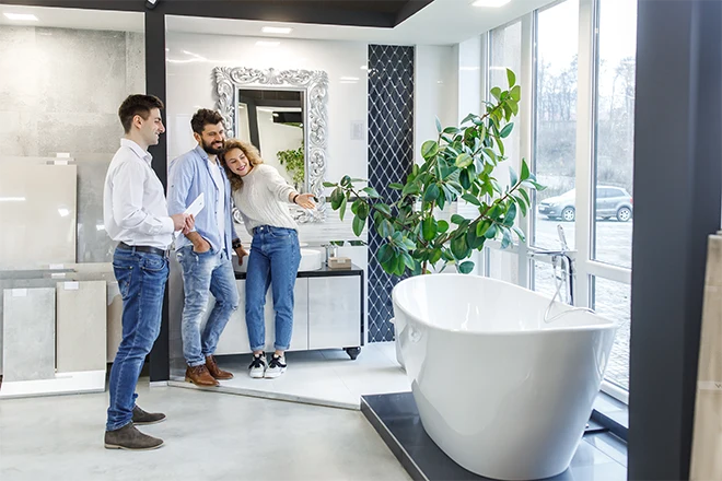 Couple with a designer looking at a bathtub in a show room