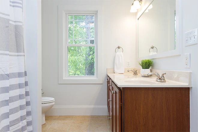 Hall bathroom with shower and wood vanity and window