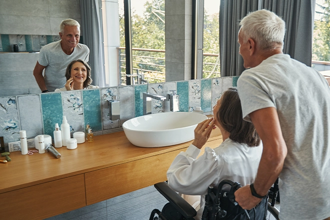 Woman in wheelchair doing makeup in an accessible bathroom