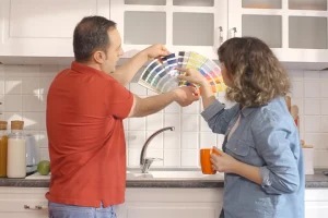 Couple picking out paint colors after knowing the best type of paint for kitchens