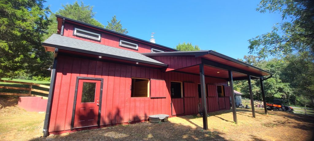 Large red barn with stables for horses