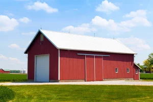 Large barn garage that is red with a white door